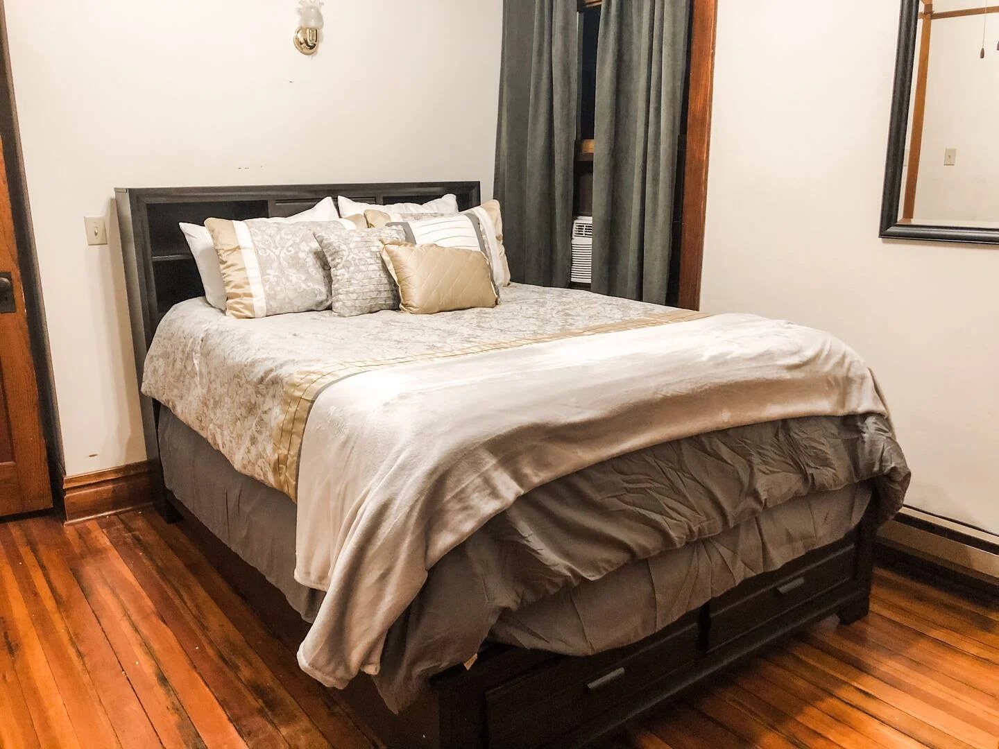 Bedroom with queen bed and warm wood floors